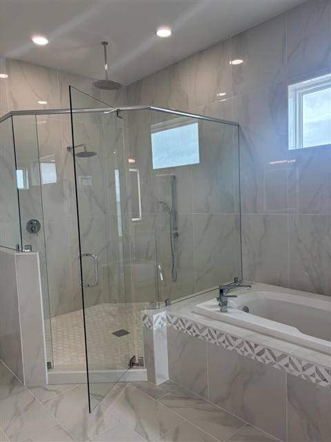 Frameless glass shower and tiled tub deck
