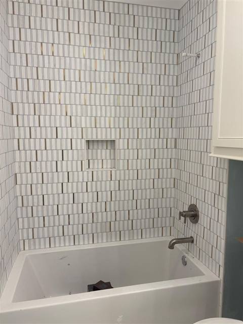 Stone mosaic tub surround with brass inlay